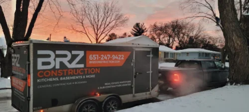 BRZ Construction branded service trailer parked at residential property in winter