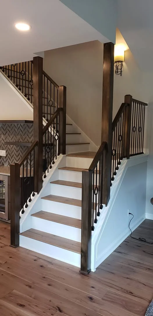 Modern staircase with dark wood railings and white risers in residential home