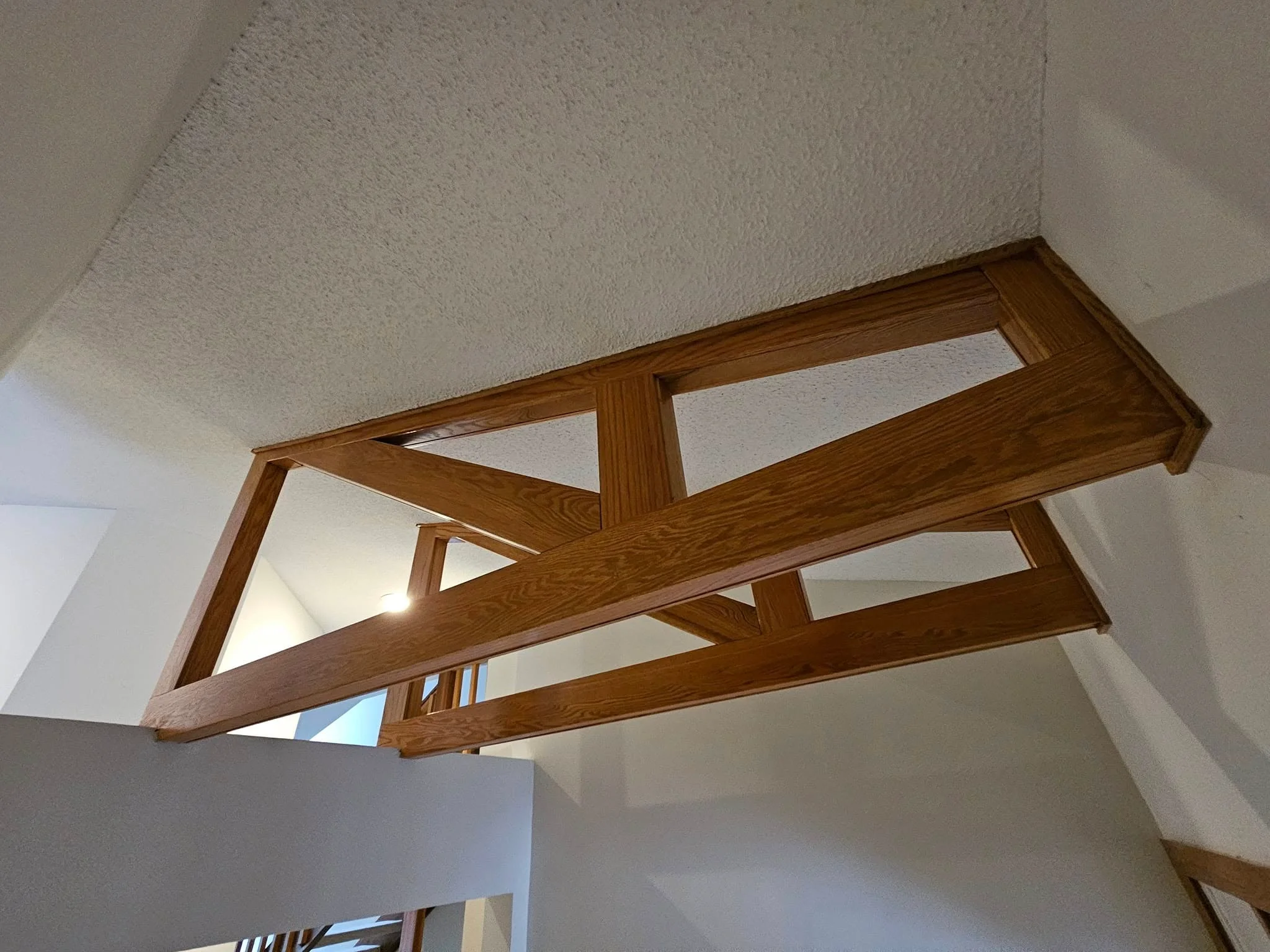 Custom wooden beams installed in ceiling with oak finish and exposed joinery